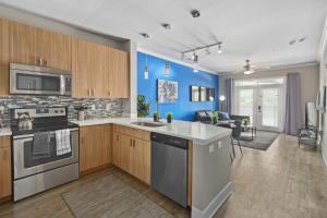 罗利City Living in Downtown Raleigh Luxury Apt 1的厨房配有木制橱柜和蓝色的墙壁