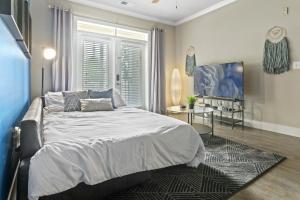 罗利City Living in Downtown Raleigh Luxury Apt 1的一间卧室设有一张大床和一个窗户。