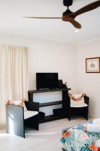 AmuriTai Marino - Beach Bungalows的一间带电视和两把椅子的客厅