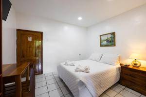 阿约拉港La Peregrina Galapagos B&B的一间卧室配有一张床、一张桌子和一张桌子