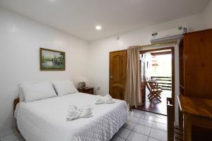 阿约拉港La Peregrina Galapagos B&B的一间卧室配有一张带白色床罩的床