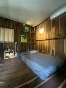 胡志明市Cactos Bar & Homestay的木墙客房的一张床位