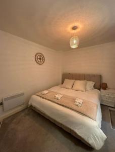 布雷得佛Dream Retreat Luxury Apartment with Super King Bed, Pool Table PS4 - Sleeps 5 Free Parking的卧室配有一张床,墙上挂着一个钟