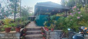 马迪凯里Madhuvana Guest House的花园中种植植物的小建筑