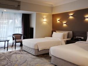甲抛峇底Bertam Resort,Penang的酒店客房设有两张床和一张桌子。