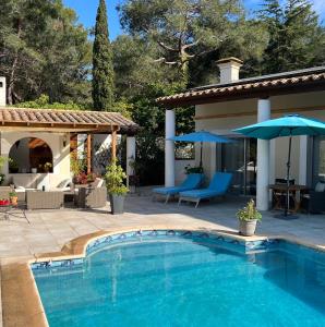 阿格德角VILLA NATURISTE JO&SPA ANNA'BELLA Luxury Suites "naturist couples only"的游泳池位于带遮阳伞的庭院旁