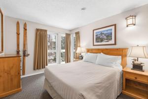 惠斯勒坦塔罗斯度假旅馆的一间卧室设有一张床和一个窗口