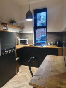 罗奇代尔2 BDR House - Ideal for Short Breaks & Contractors的厨房配有桌子和带微波炉的台面