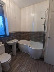 罗奇代尔2 BDR House - Ideal for Short Breaks & Contractors的带浴缸、卫生间和盥洗盆的浴室