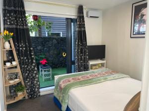 奥克兰Auckland CBD, Parnell Ensuite+Patio+Secluded Garage的一间卧室设有一张床和一个窗口