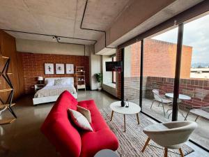 危地马拉Artistic Apartment in Zone 4的客厅配有红色的沙发和床。