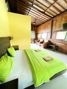 索龙Mooipark Hotel Sorong的一张带绿色床单的大床