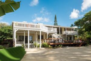 拉罗汤加穆里泻湖碧斯海滨度假屋的大型白色房屋设有门廊和阳台