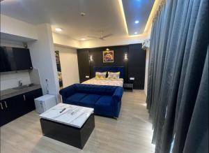 勒克瑙Royal Suites INN的一间卧室配有一张床和一张蓝色的沙发