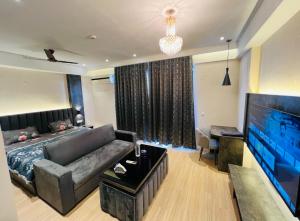 勒克瑙Royal Suites INN的带沙发和平面电视的客厅
