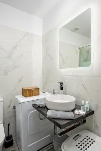 梅萨雷亚Marillia's elegance residence的白色的浴室设有水槽和洗衣机。