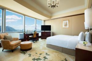 温州温州香格里拉的酒店客房设有一张床、一张书桌和一个大窗户。