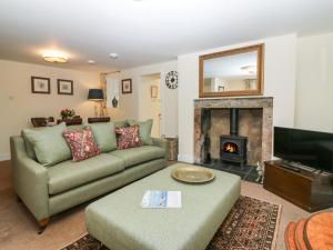 AlfordNorth Mains Cottage - Craigievar Castle的带沙发和壁炉的客厅