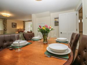 AlfordNorth Mains Cottage - Craigievar Castle的用餐室,配有带盘子和鲜花的桌子