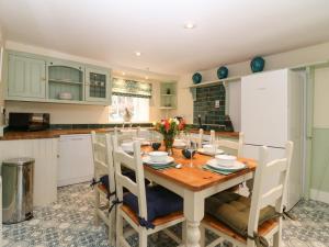 AlfordSouth Mains Cottage - Craigievar Castle的厨房配有木桌和椅子