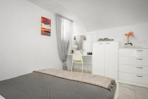 梅萨雷亚Marillia's elegance residence的一间卧室配有一张床、梳妆台和书桌