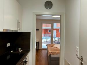 格拉茨sHome Apartments Graz - Self-Check-in & free parking的厨房配有桌子和墙上的时钟