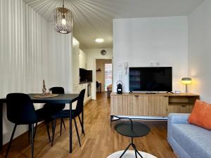 格拉茨sHome Apartments Graz - Self-Check-in & free parking的带沙发、桌子和电视的客厅