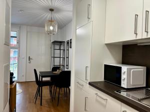 格拉茨sHome Apartments Graz - Self-Check-in & free parking的厨房配有微波炉和桌椅