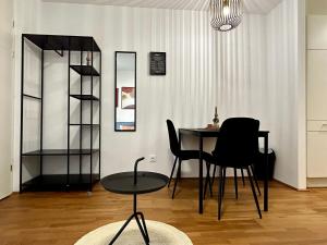 格拉茨sHome Apartments Graz - Self-Check-in & free parking的一间带桌子和两把椅子的用餐室