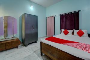 加雅OYO Flagship Magadh Guest House的一间卧室配有一张床、梳妆台和电视。