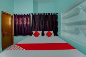 加雅OYO Flagship Magadh Guest House的一间卧室配有一张带红色枕头的床和一扇窗户