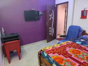 钦奈Blue Diamond的一间卧室配有一张床,紫色墙壁上配有电视