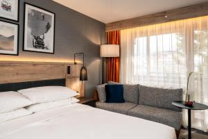 班斯科Four Points by Sheraton Bansko的酒店客房,配有床和沙发