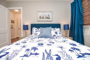 安娜玛丽亚Casa Posada - So Close You Can Hear the Waves Historic Beach Cottage w Beach Gear的一间卧室配有蓝色和白色的床以及蓝色窗帘