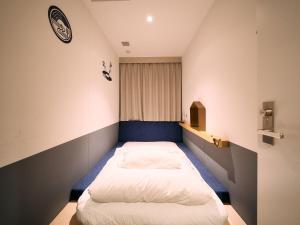 川崎Hotel Plus Hostel TOKYO KAWASAKI的一间小卧室,内配两张床