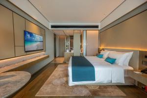 西哈努克Blue Bay International Resort Hotel的一间带大床和电视的卧室