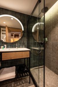 班斯科Four Points by Sheraton Bansko的带淋浴、盥洗盆和镜子的浴室