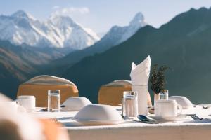 KongdeMountain Lodges of Nepal - Kongde的一张桌子,上面有盘子和餐巾,上面有山