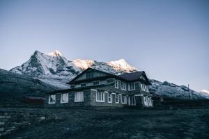 KongdeMountain Lodges of Nepal - Kongde的一座有雪覆盖的山丘的古老房子