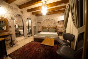 格雷梅Ares Cave Suites的一间卧室配有一张床、一张桌子和一个浴缸