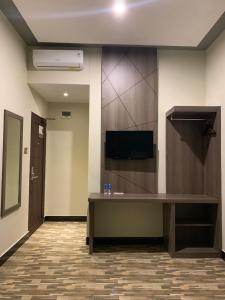 SintangBless Hotels的客房设有书桌和墙上的电视