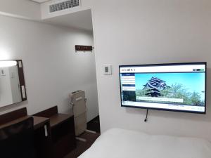 松江市Hotel Alpha-One Matsue的挂在墙上的平面电视