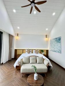 后川Tropicana Hồ Tràm - Seashell Villa的一间卧室配有一张床和吊扇