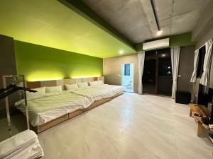 礁溪21稻香民宿的一间卧室配有一张带绿色墙壁的床