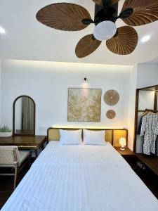 后川Tropicana Hồ Tràm - Seashell Villa的一间卧室配有一张带吊扇的床