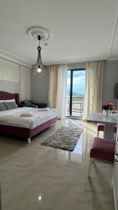 兹拉蒂博尔Zlatibor Hills Apartments Wellness & Spa的一间大卧室,配有一张床和一个大窗户