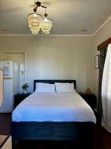 诺瑟姆Charming Brick Homestay Room in Northam的一间卧室配有白色的床和2个吊灯