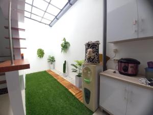 玛琅Villa Estetis di Kota Batu的一间位于客房中间的绿色地毯厨房