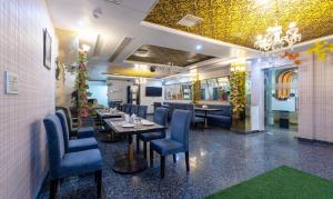 勒克瑙Treebo Trend Shakuntalam的餐厅设有一张长桌和蓝色椅子