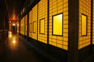 白石市托基恩诺亚都玉努时其乔旅馆的走廊设有黄色的瓷砖墙壁和窗户